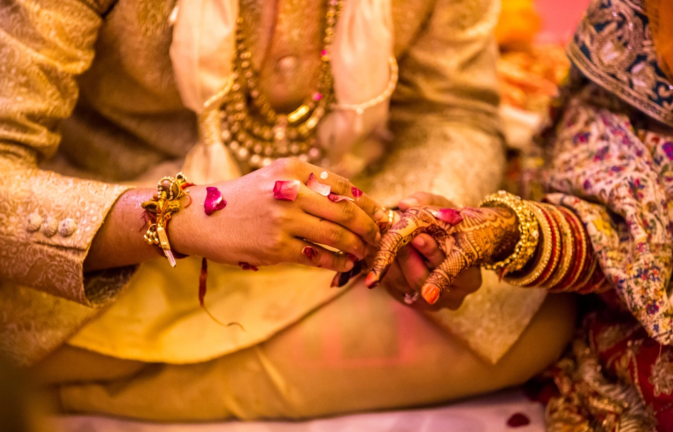 Wedding image where a man putting ring to women.