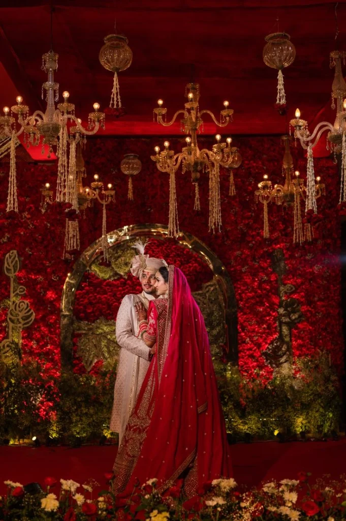 Wedding Image of a couple with beautiful red flower decorated background- Mehdi Events