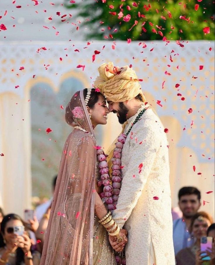 Happy couple at their wedding in background flower petals are flying- Mehdi Events